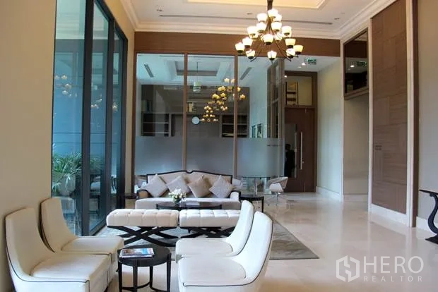 公寓 出租在Ratchathewi, Bangkok - 公寓大堂配沙发休息区与吊灯，落地玻璃墙通透明亮。