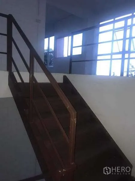 Warehouse for rent in Pathum Thani - Metal staircase with handrail leading to upper office area inside the warehouse