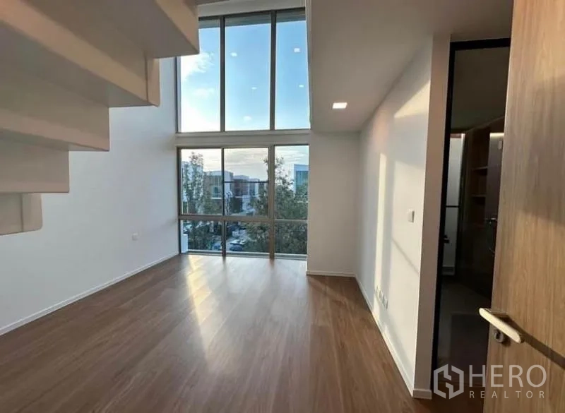 Detached House for rent - Bedroom with towering windows beneath a floating staircase and a walk-in closet door.