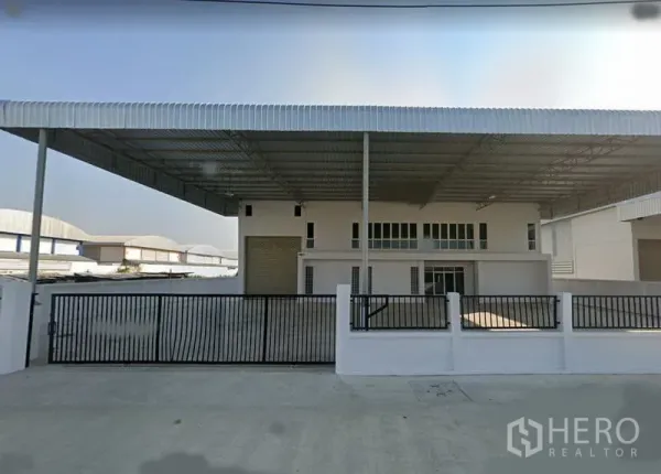 Factory for rent or sale in Bang Bo, Samut Prakan - Front view of a standalone factory in Bang Bo with a wide covered loading canopy and gated entrance.