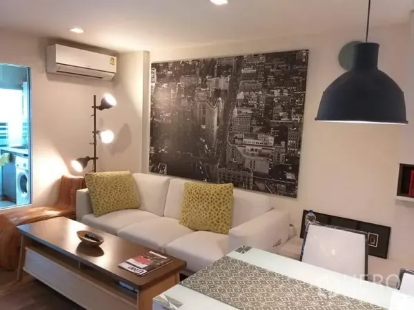 คอนโด ให้เช่าในWatthana, Bangkok - มุมนั่งเล่นอบอุ่น มีภาพเมือง โคมไฟแขวน และเครื่องปรับอากาศติดผนัง