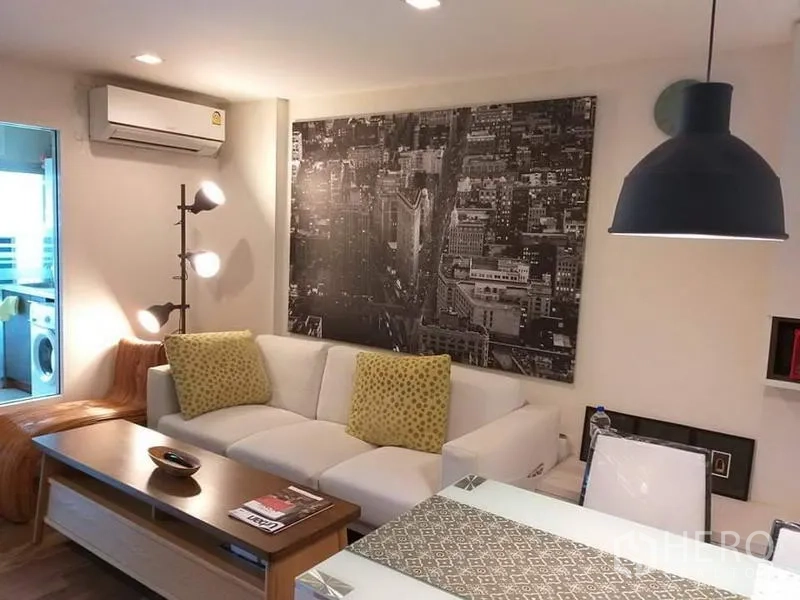 คอนโด ให้เช่าในWatthana, Bangkok - มุมนั่งเล่นอบอุ่น มีภาพเมือง โคมไฟแขวน และเครื่องปรับอากาศติดผนัง