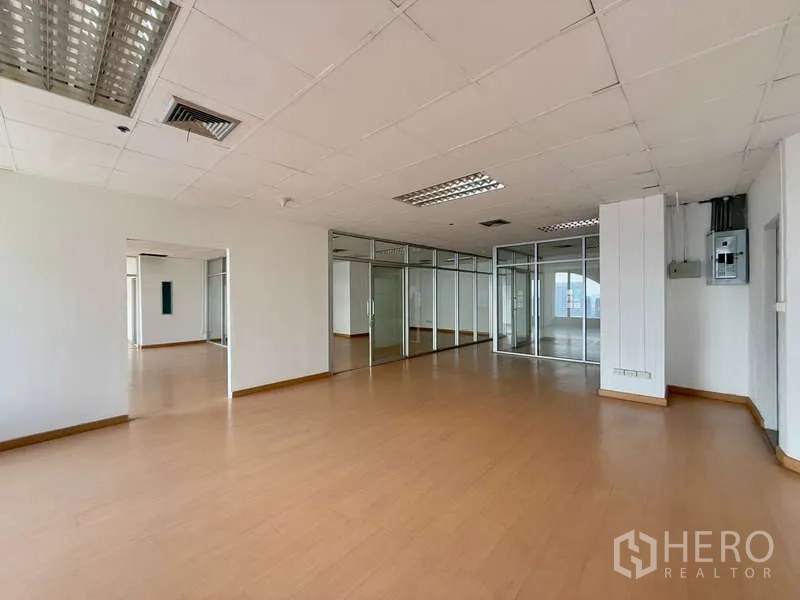 办公空间 出租在Chatuchak, Bangkok - 宽敞办公室，玻璃墙、电控箱与嵌入式灯具吊顶。