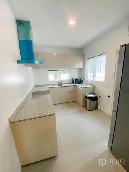 Detached House for rent in Prawet, Bangkok - Separate light-filled kitchen with stone countertops, cooktop and range hood.