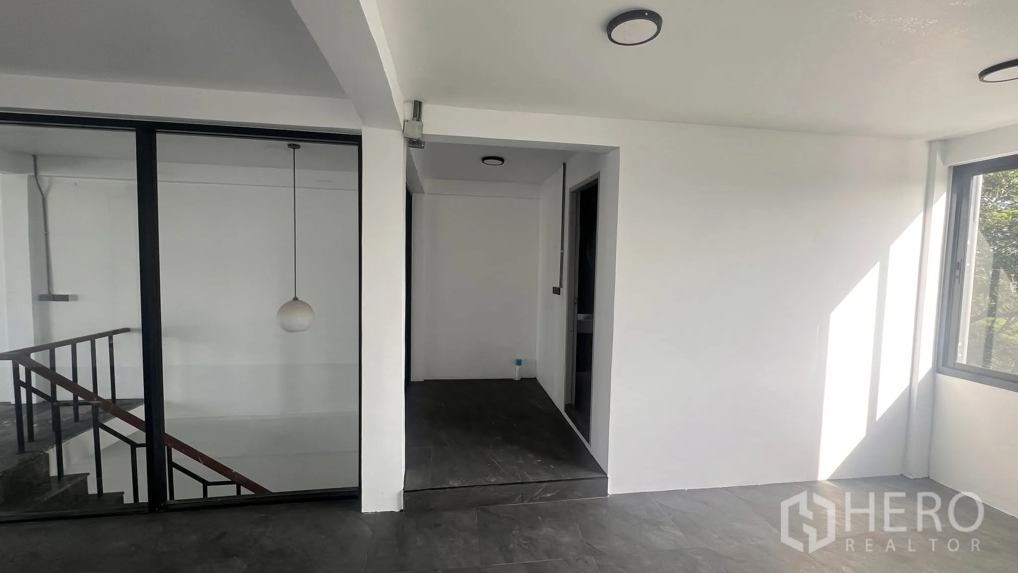 โฮมออฟฟิศ for rent or sale in Phra Khanong, Bangkok - โถงทางเชื่อมสว่างพร้อมผนังกระจก โคมแขวน และหน้าต่าง.