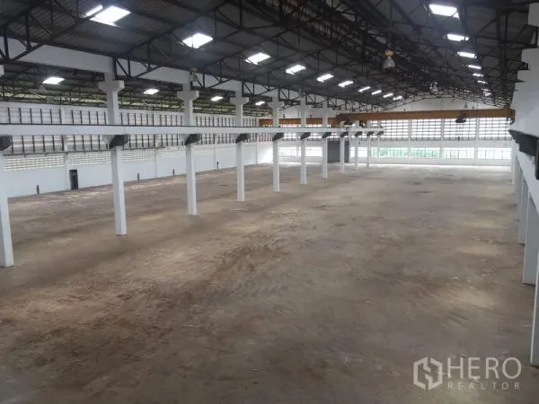 Warehouse for rent in Lam Luk Ka, Pathum Thani - Panoramic view of a clear-span warehouse hall with ventilation blocks, abundant natural light, and expansive floor area.