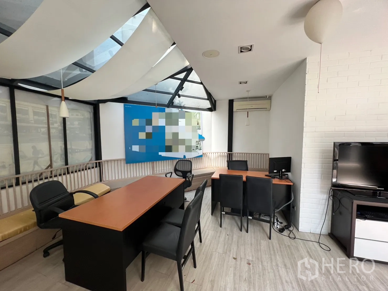 零售空间 出租在Pathum Wan, Bangkok - 会谈与销售区域，配桌椅、白砖墙与天窗式顶棚。