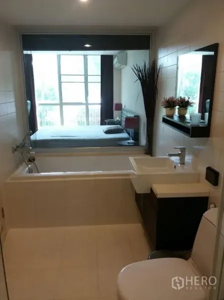 คอนโด ให้เช่าในPhaya Thai, Bangkok - ห้องน้ำสมัยใหม่พร้อมอ่างอาบน้ำ อ่างล้างหน้า และหน้าต่างเชื่อมมองไปยังห้องนอนที่มีหน้าต่างบานใหญ่