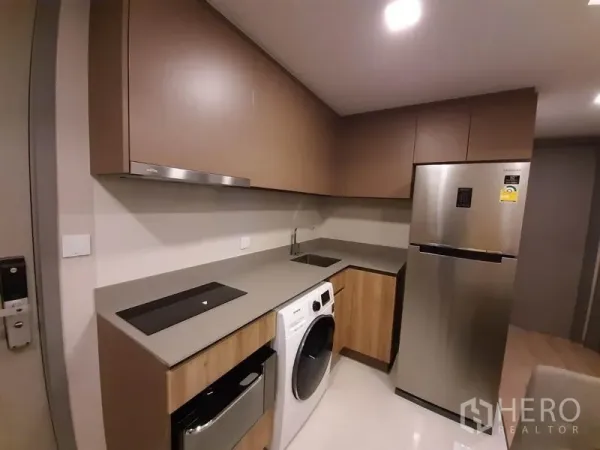 คอนโด ให้เช่าหรือขายในWatthana, Bangkok - ครัวบิวท์อินเคาน์เตอร์หิน เตาไฟฟ้า เครื่องซักผ้า และตู้เย็นสแตนเลส