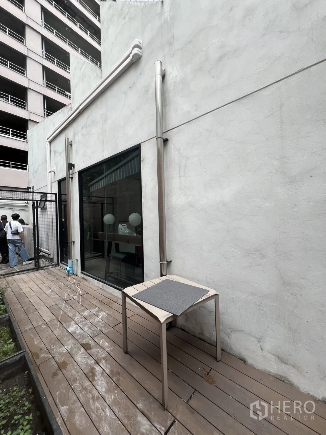 อาคารพาณิชย์ ให้เช่าในBang Rak, Bangkok - ทางเดินเด็คไม้ข้างอาคาร ผนังปูนขาวและประตูกระจก