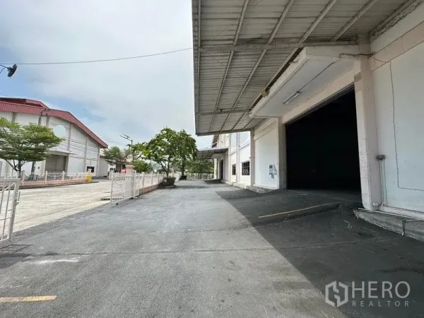 货栈 出租在Bang Sao Thong, Samut Prakan - 带雨棚的装卸平台与坡道，仓库侧边铺装场地宽敞。