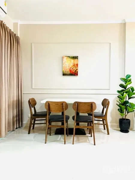 联排别墅 出租 - 四人餐区，木椅、素雅墙面与绿植点缀。