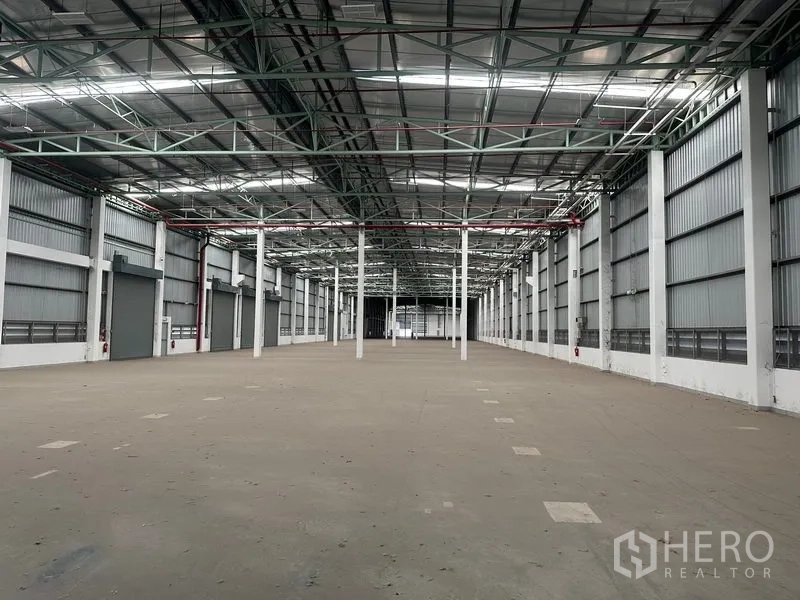 工厂 出租在Bang Sao Thong, Samut Prakan - 仓库内部侧墙分布多扇装卸门，屋顶挑高