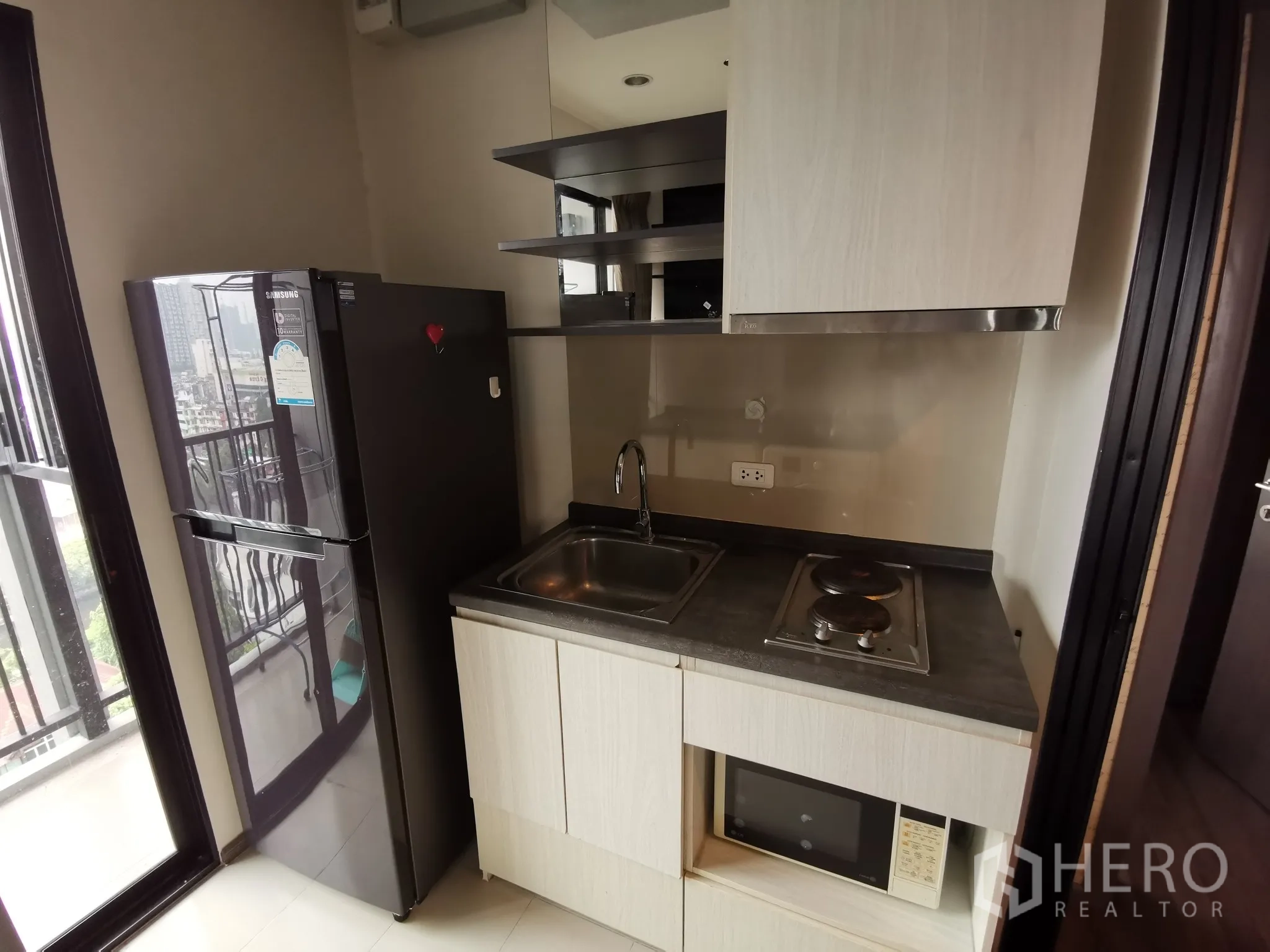 公寓 出租或出售在Watthana, Bangkok - 紧凑厨房配冰箱、电炉、洗菜盆与嵌入式微波炉。