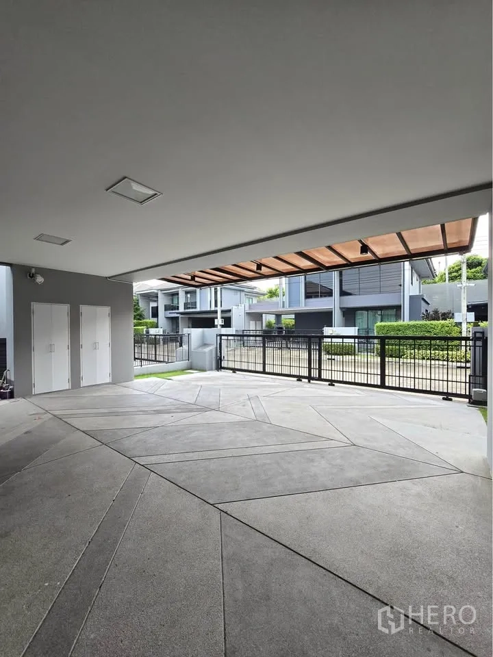 บ้านเดี่ยว for rent in Bang Kapi, Bangkok - ที่จอดรถมีหลังคาพร้อมประตูรั้วเลื่อน มองเห็นบ้านสไตล์โมเดิร์น