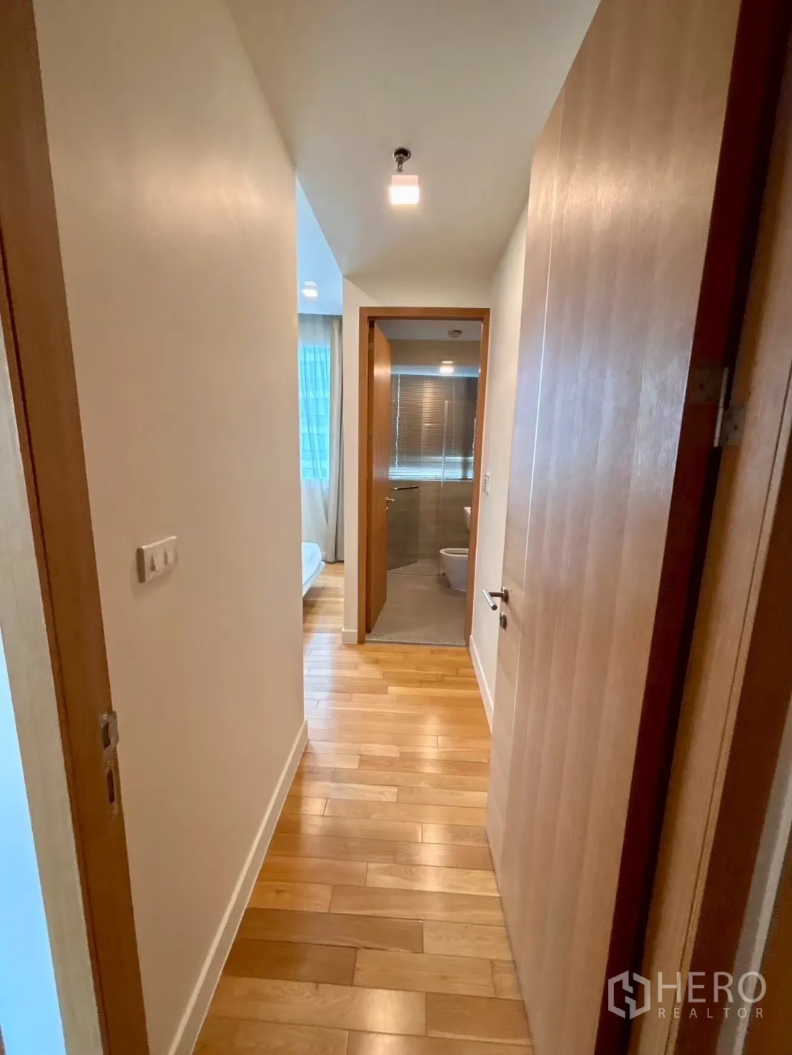 Condominium for rent in Khlong Toei, Bangkok - Hallway with wood flooring leading to bathroom and bedroom