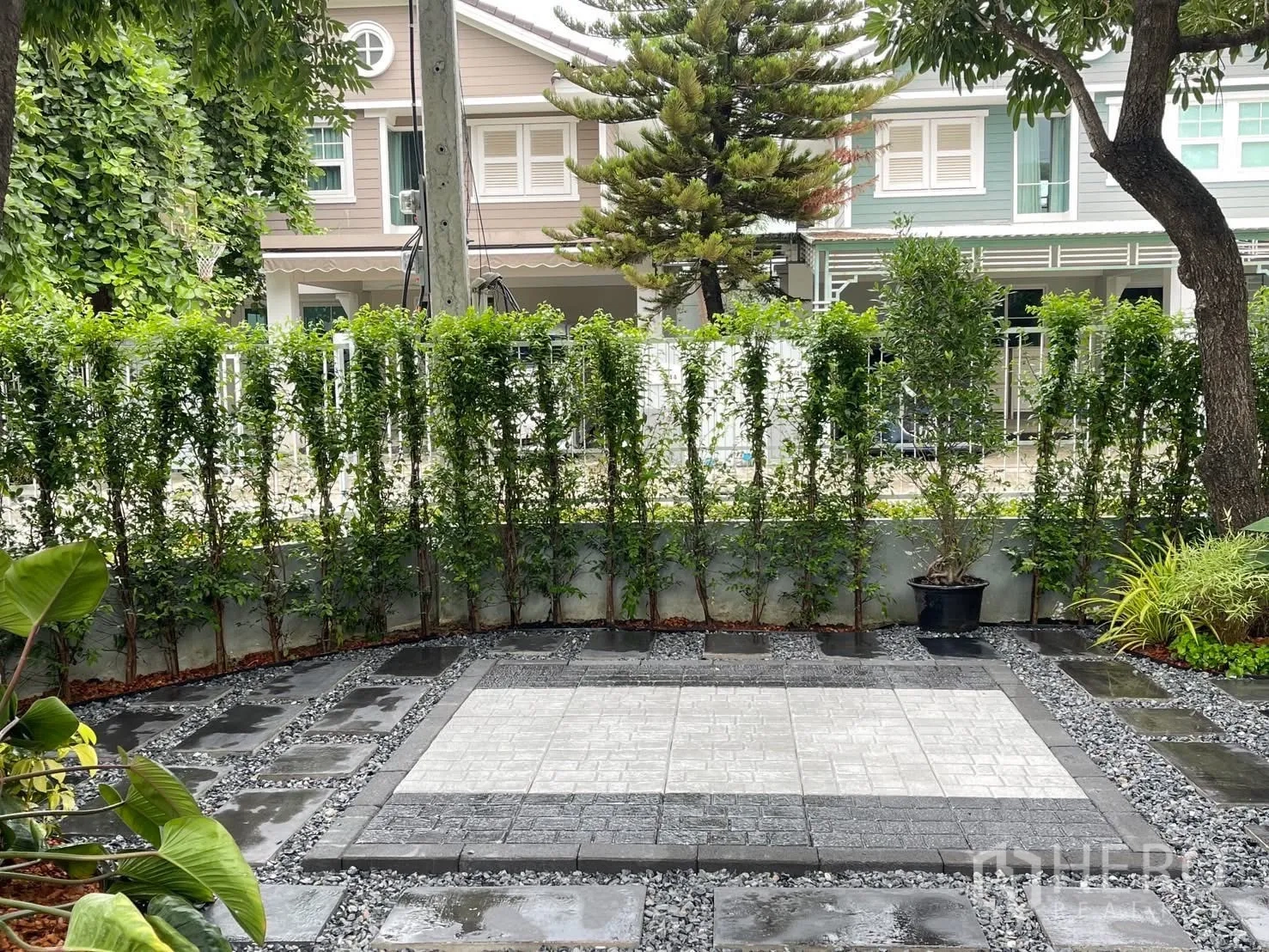 Detached House for rent in Bang Phli, Samut Prakan - Landscaped front garden with paved patio, hedge and view of neighboring houses.