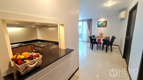 อพาร์ทเมนท์ ให้เช่าในWatthana, Bangkok - ช่องเสิร์ฟจากโถงไปยังครัวขนาดกะทัดรัด พร้อมท็อปหินแกรนิตและตะกร้าผลไม้