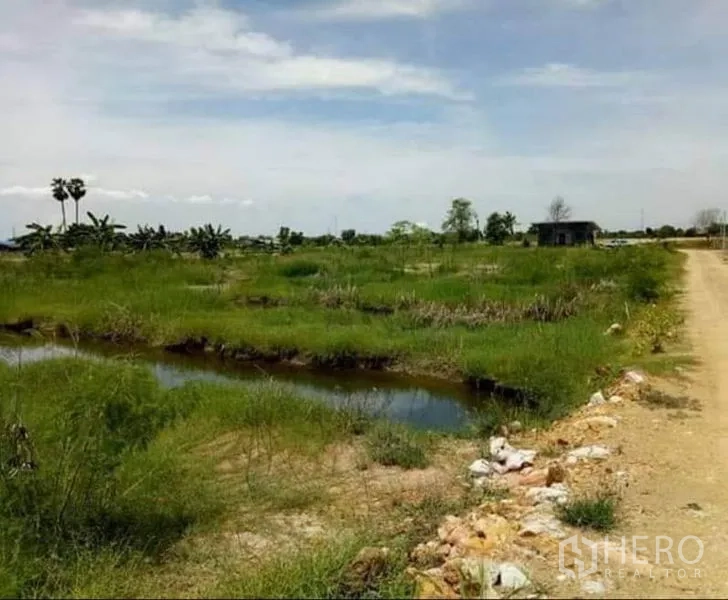 ที่ดิน ขายในBan Pho, Chachoengsao - ที่ดินโล่งมีคูน้ำและถนนลูกรัง ภายใต้ท้องฟ้าโปร่ง