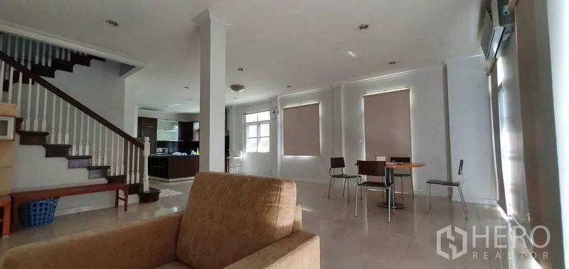 Detached House for rent in Prawet, Bangkok - Spacious living and dining zone with tiled floors and stairway to the upper level.