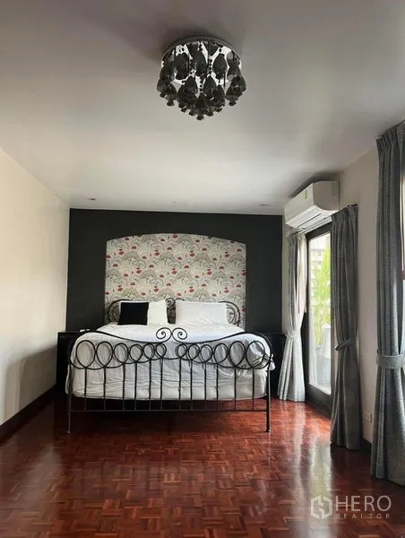 Townhouse for rent in Phaya Thai, Bangkok - Spacious bedroom with iron bed, chandelier, parquet floor and balcony doors.