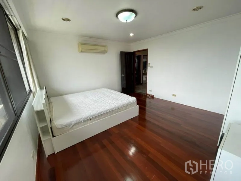 คอนโด ให้เช่าในWatthana, Bangkok - ห้องนอนรองสว่าง พื้นไม้ เตียง และเครื่องปรับอากาศติดผนัง