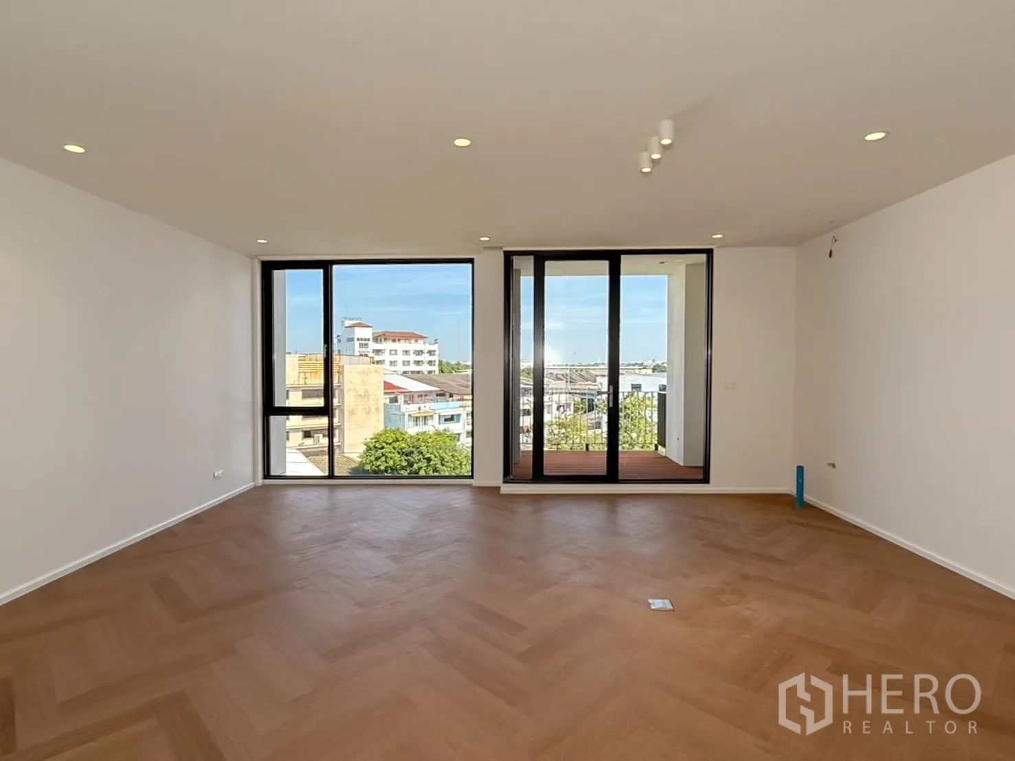 家庭办公室 for rent or sale in Watthana, Bangkok - 高层房间通向小阳台，城市景观。