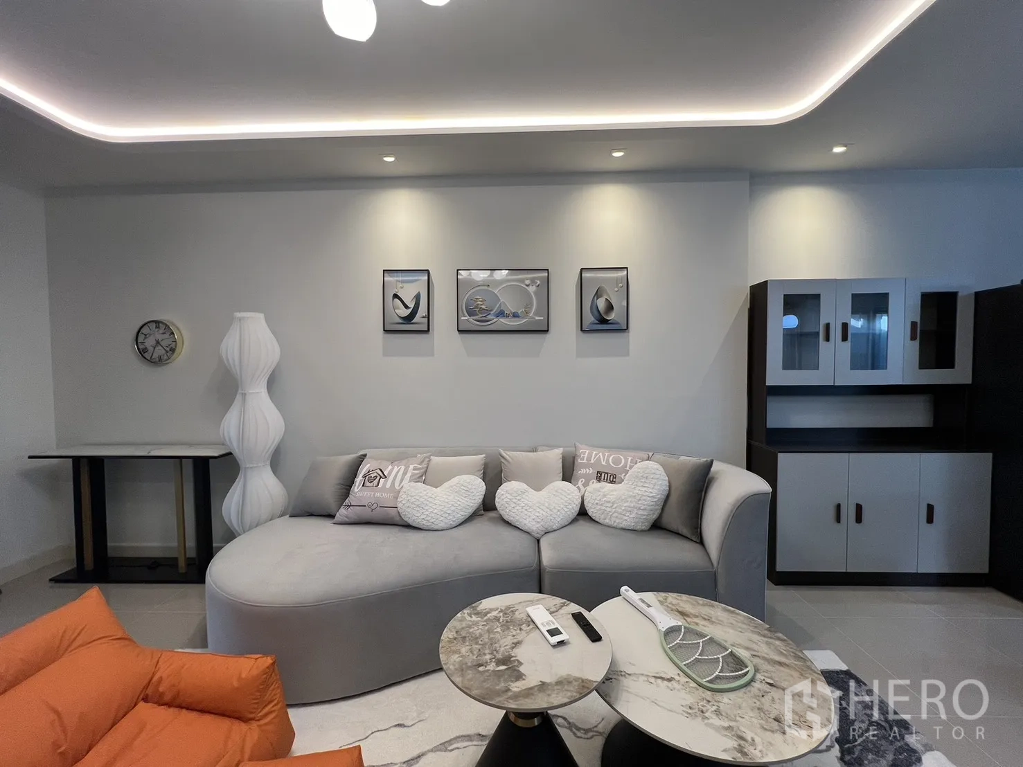 Townhouse for rent in Bang Phli, Samut Prakan - Cozy living room with a curved sofa, coffee tables and built-in cabinetry.