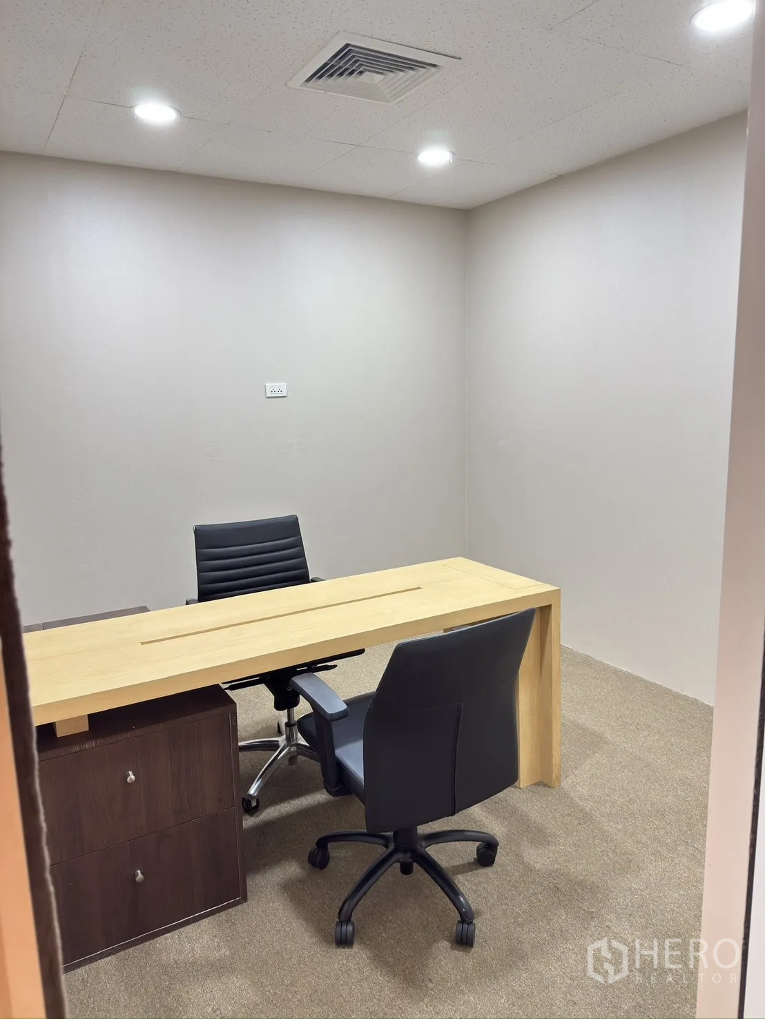Retail Space for rent in Khlong Toei, Bangkok - Meeting room with a wooden table, two chairs, carpet, and recessed ceiling lights.