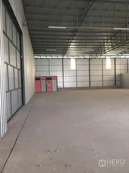 คลังสินค้า ให้เช่าในBang Kapi, Bangkok - พื้นที่โกดังเปิดโล่งพร้อมประตูเหล็กบานเลื่อน พื้นคอนกรีต ตู้เก็บของ และเพดานโครงทรัสสูง
