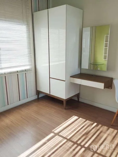 Townhouse for rent in Saphan Sung, Bangkok - Bedroom corner with white wardrobe, floating vanity, striped wallpaper and wood flooring.