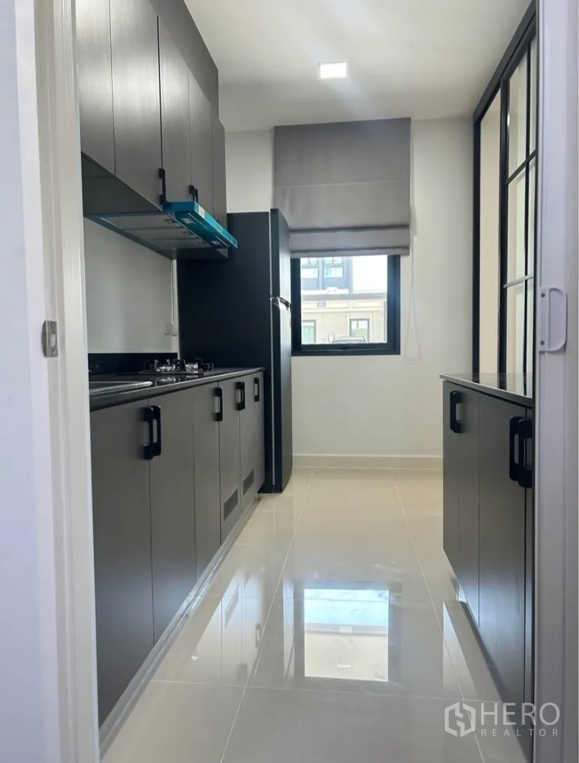 บ้านแฝด for rent in Bang Phli, Samut Prakan - ครัวสไตล์แกลเล่ย์ตู้สีเข้ม เตาแก๊ส เครื่องดูดควัน และตู้เย็น