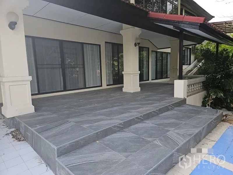 Detached House for rent - Spacious covered front terrace with grey stone tiles and floor-to-ceiling sliding glass doors.