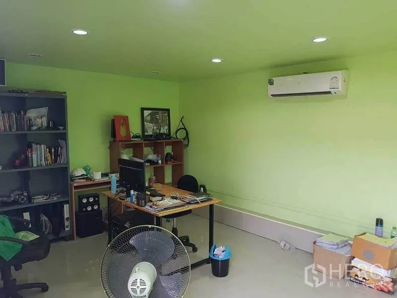 Warehouse for rent in Sai Noi, Nonthaburi - Air-conditioned office room with green walls, desk and shelving.