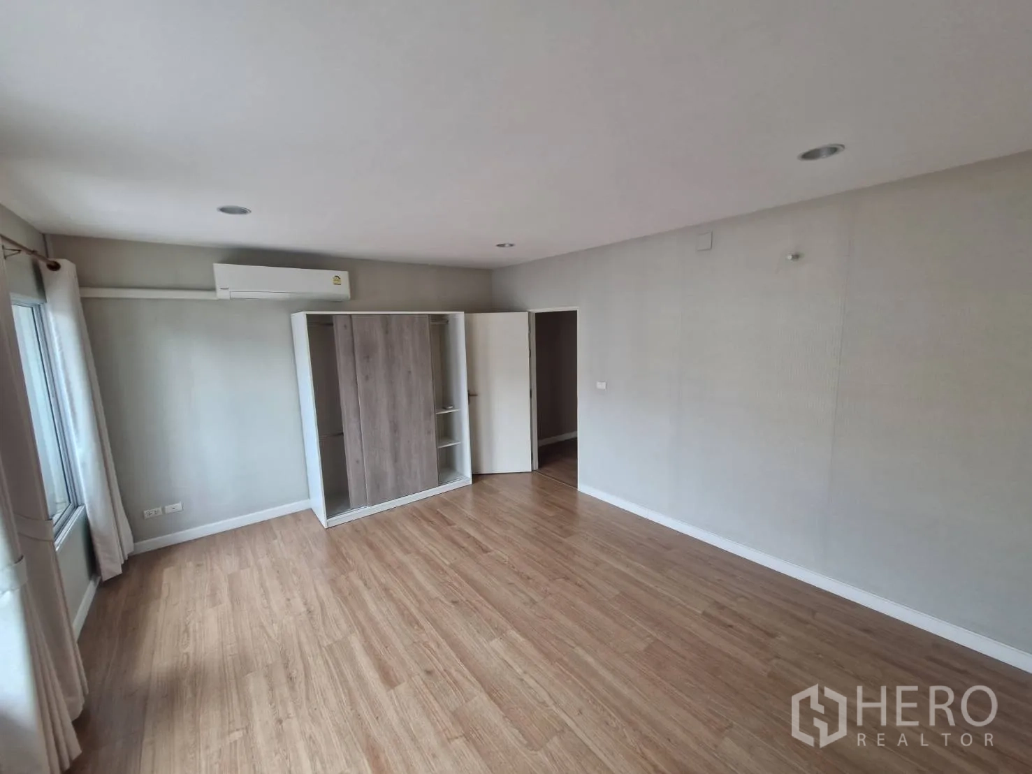 Townhouse for sale in Rat Burana, Bangkok - Master bedroom view with wardrobe, air-conditioning, and laminate flooring.