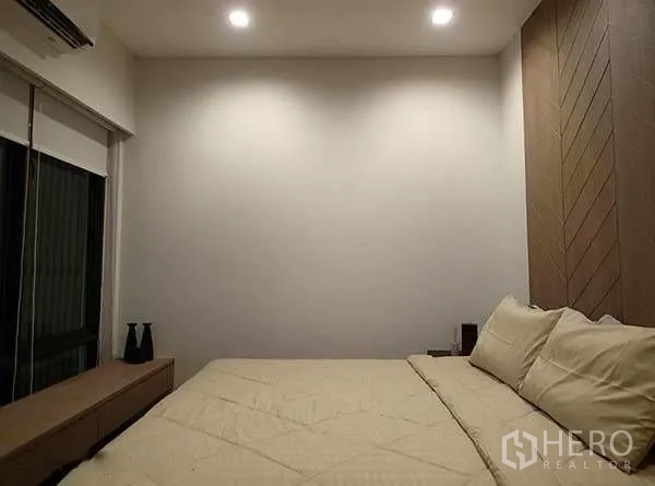 Townhouse for rent in Watthana, Bangkok - Second bedroom with double bed, soft lighting, and minimalist decor.
