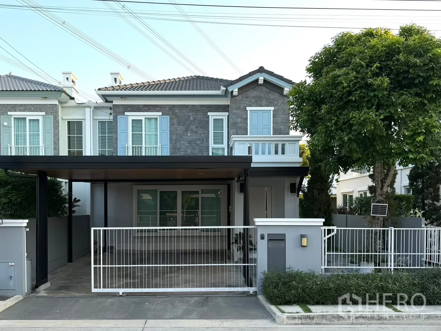 Semi-detached House for rent in Prawet, Bangkok - Exterior facade of a semi-detached house with gated front yard and carport.