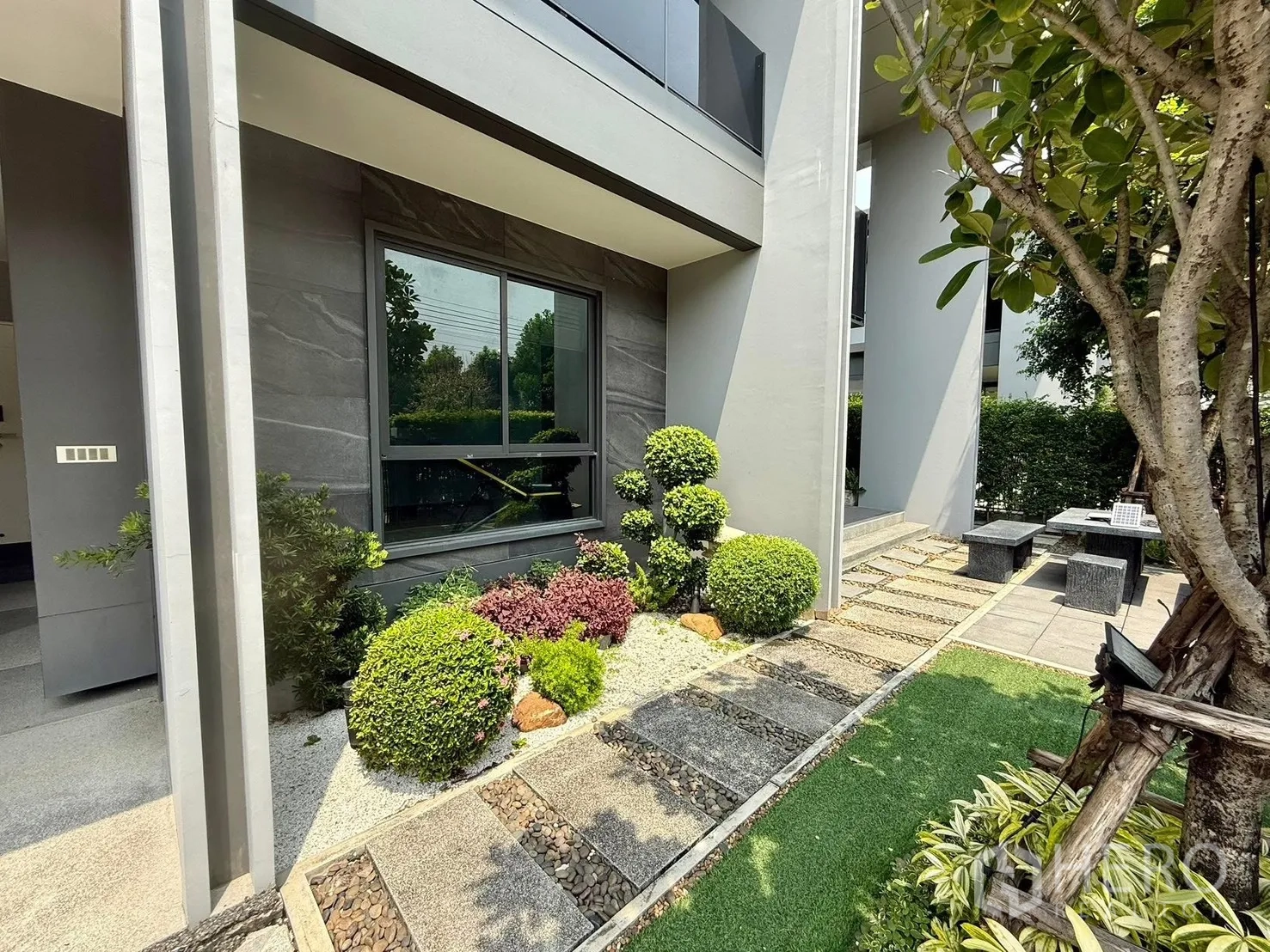 Detached House for rent in Bang Kapi, Bangkok - Landscaped front yard with shaped shrubs, rock garden and outdoor patio seating.