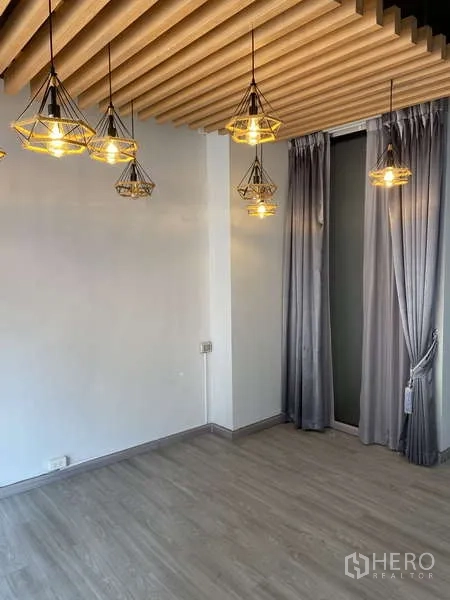 Home Office for rent or sale - Cozy room with cluster pendant lights, slatted ceiling accent, grey drapes and wood flooring.
