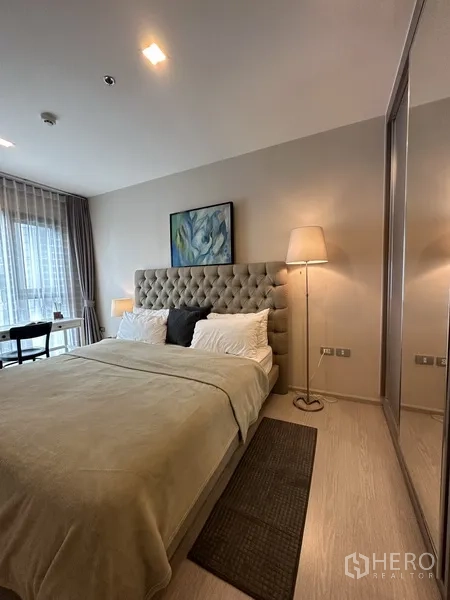 คอนโด ให้เช่าหรือขายในKhlong Toei, Bangkok - ห้องนอนใหญ่หัวเตียงบุผ้า โคมไฟข้างเตียง และตู้เสื้อผ้าบานกระจก