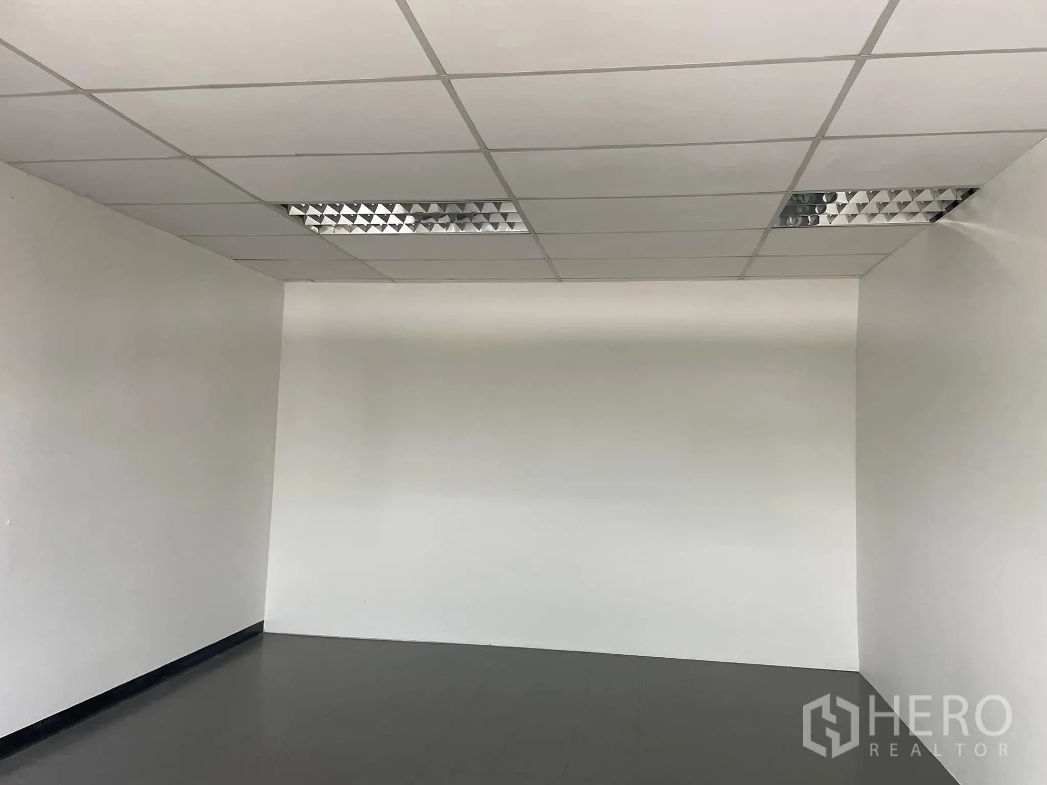 Office Space for rent in Lat Phrao, Bangkok - Empty room with suspended ceiling and fluorescent light panels.