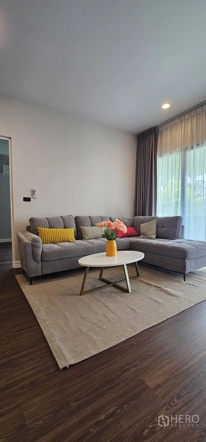 Detached House for rent in Bang Kapi, Bangkok - Upstairs family room with L-shaped sofa and wood flooring.