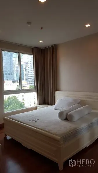 公寓 出租在Bang Rak, Bangkok - 主卧明亮，配大窗与城市景观，设有大床，位于Bang Rak公寓内。