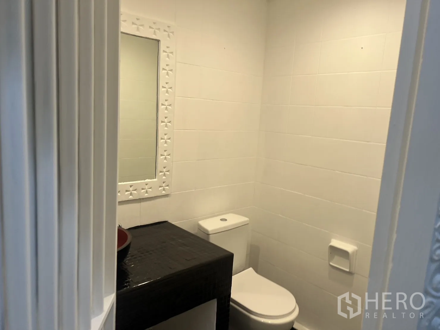 零售空间 出租在Khlong Toei, Bangkok - 现代卫生间，白色瓷砖、带框镜子与马桶。