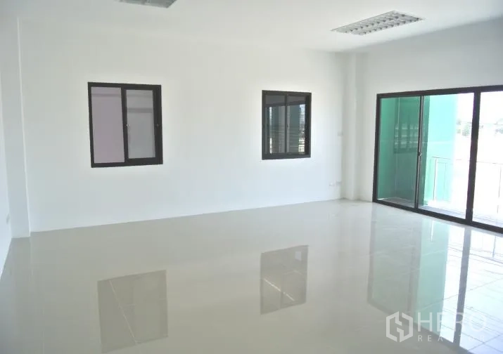 Factory for rent or sale in Bang Phli, Samut Prakan - Bright office room with glossy tiled floor, windows and a sliding glass door to a small balcony.
