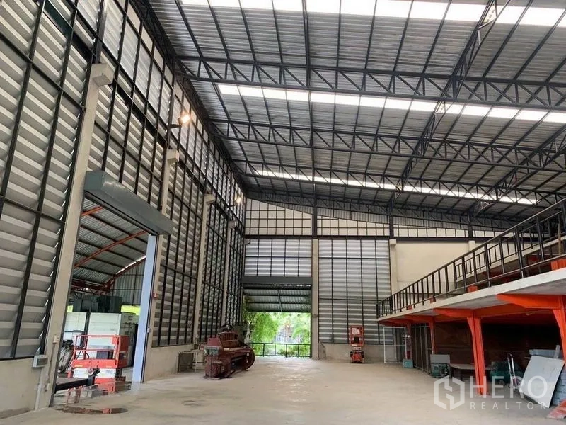 货栈 出租在Lak Si, Bangkok - 高挑仓库内部，钢结构屋顶配采光天窗，混凝土地面与夹层储物。