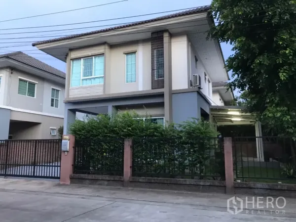 独立式住宅 出租在Saphan Sung, Bangkok - 安静社区中的两层独栋别墅外观，带围栏与绿植。