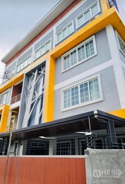 Home Office for rent or sale in Pak Kret, Nonthaburi - Modern four-storey home office facade in Pak Kret with grey and yellow accents and large windows.