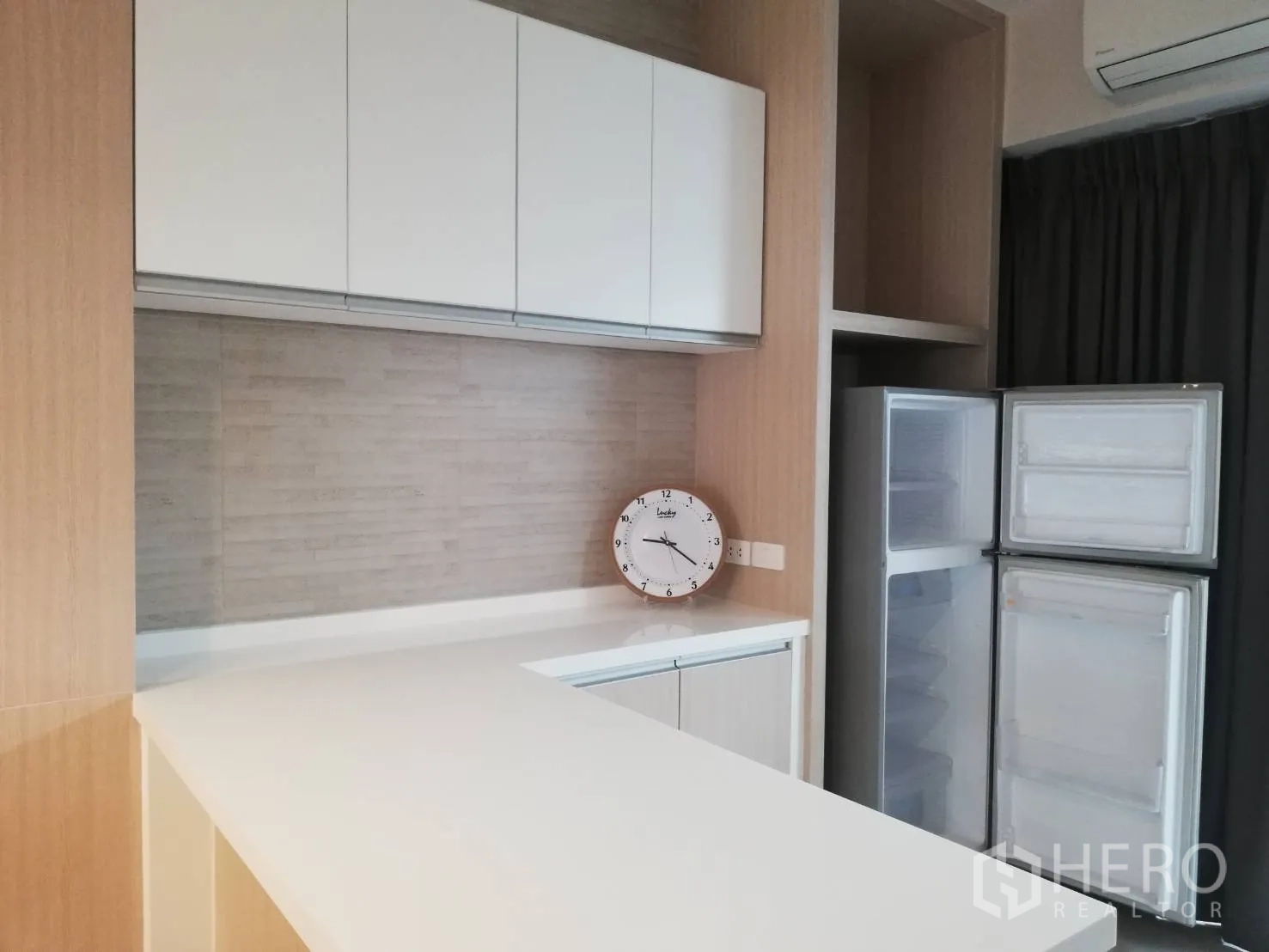 Townhouse for rent in Bang Kapi, Bangkok - Pantry area with white overhead cabinets, light wood finishes and a double-door refrigerator.
