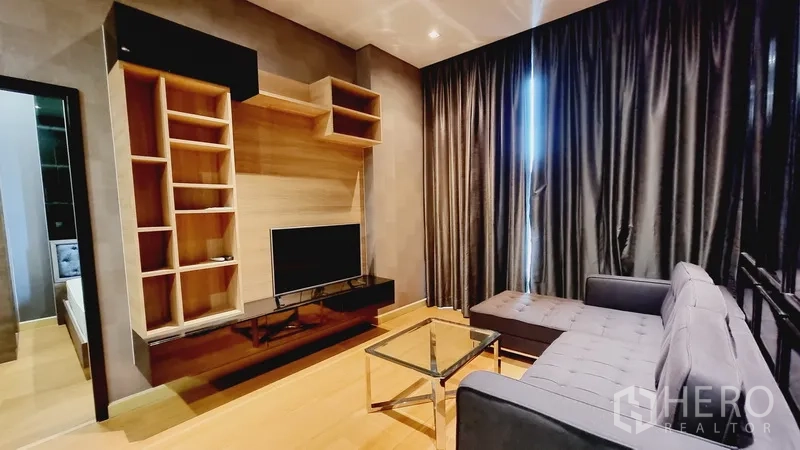 公寓 出售在Watthana, Bangkok - 客厅配转角沙发、电视墙、置物架与玻璃茶几